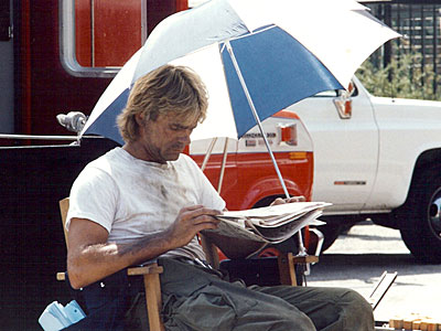 Richard reads the newspaper between takes